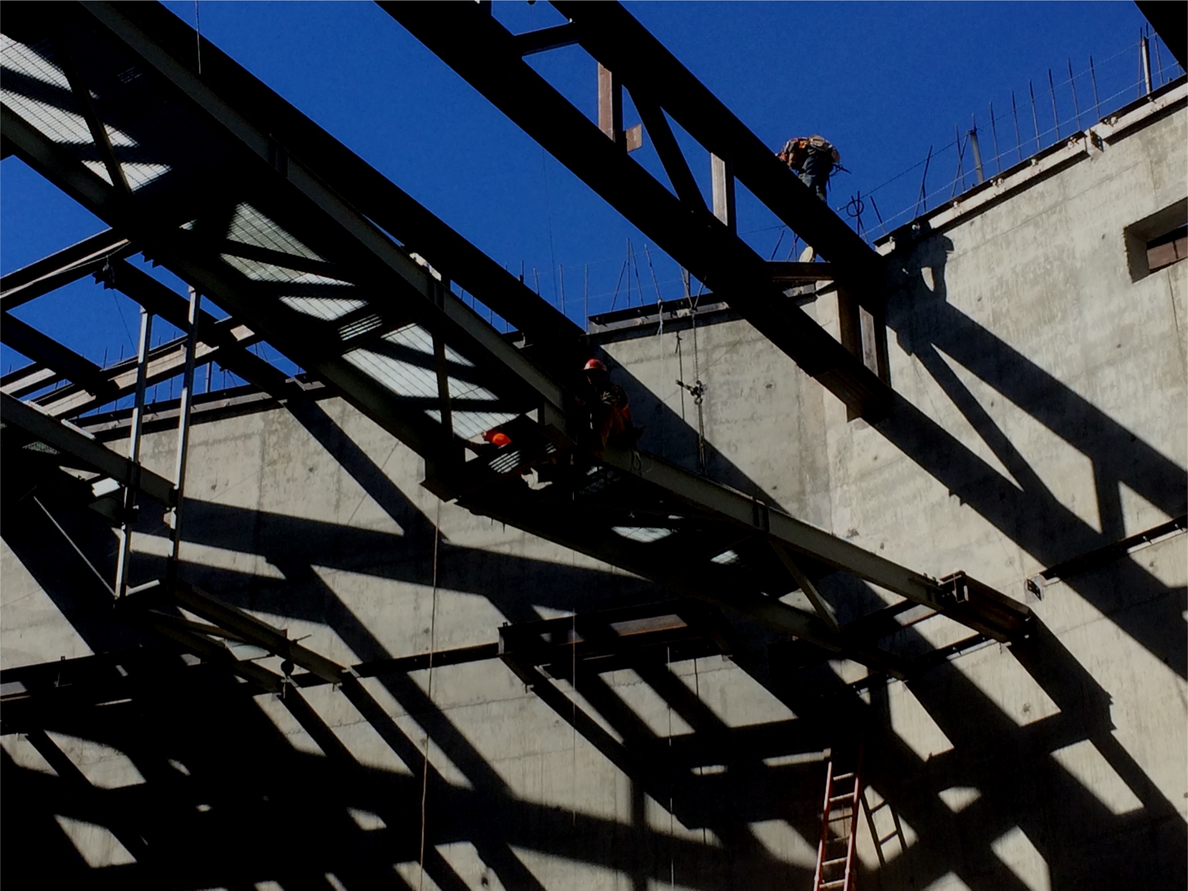 Ironworkers on a multifamily construction site at dusk